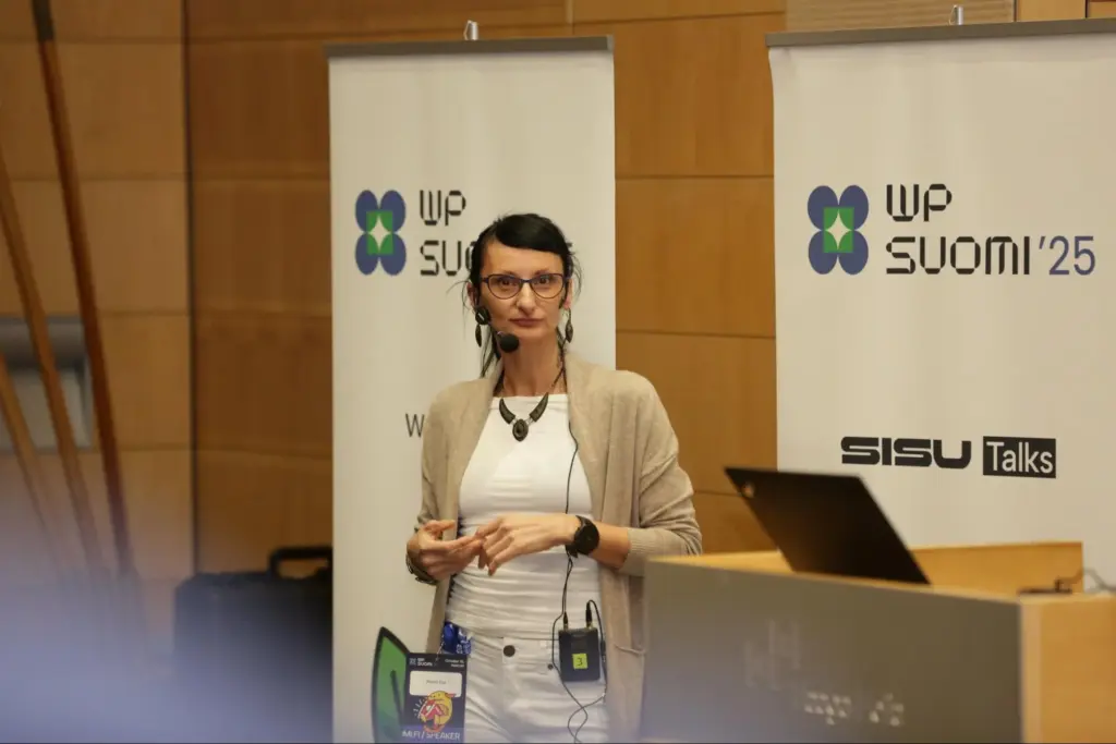 Milania Cap near a presentation podium.