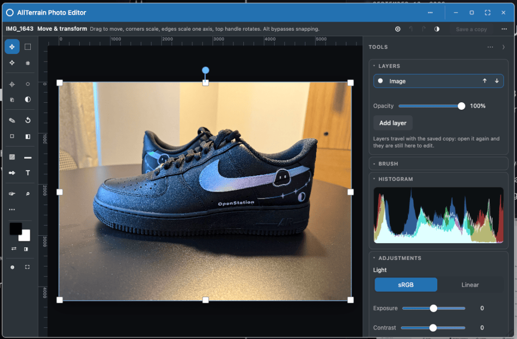 A black Nike Air Force 1 sneaker displayed on a table, featuring a blue swoosh and 